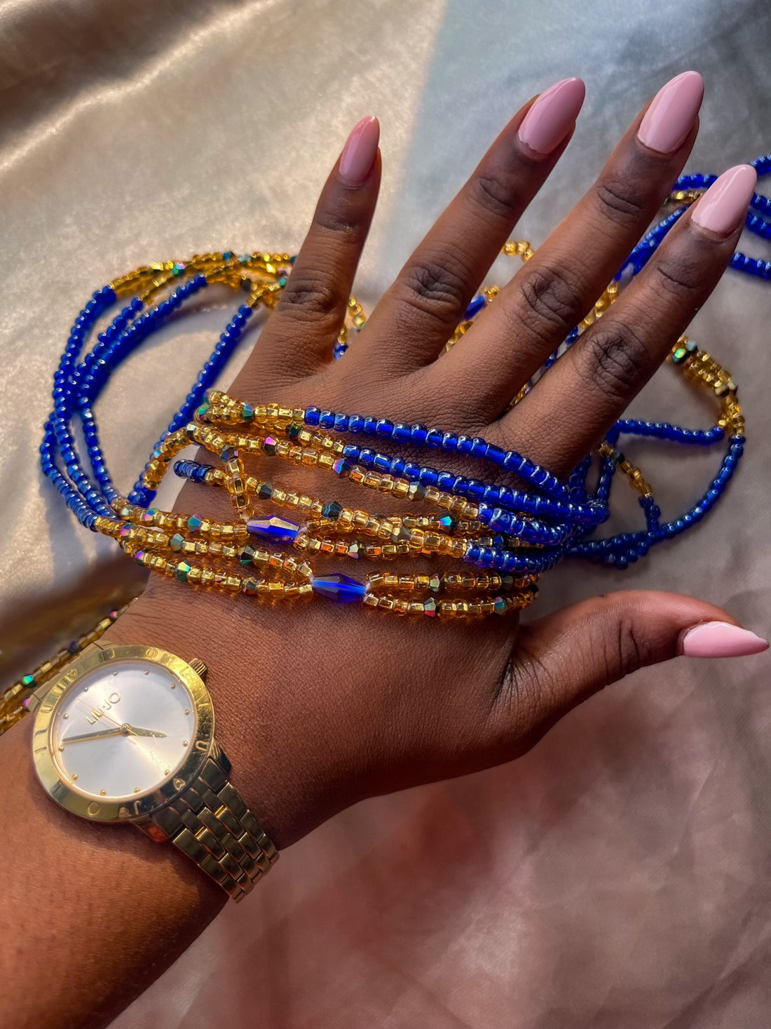 blue african waist beads on dark skin hand. top view